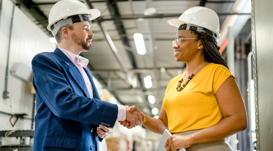 two workers in hard hats conversing