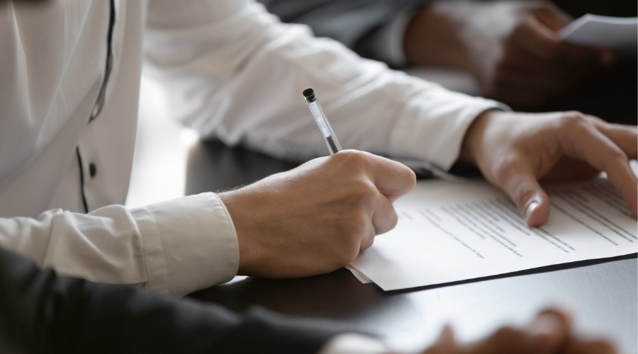 man signing document