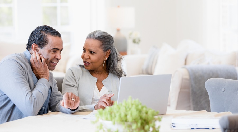 couple discussing topic while looking at computer