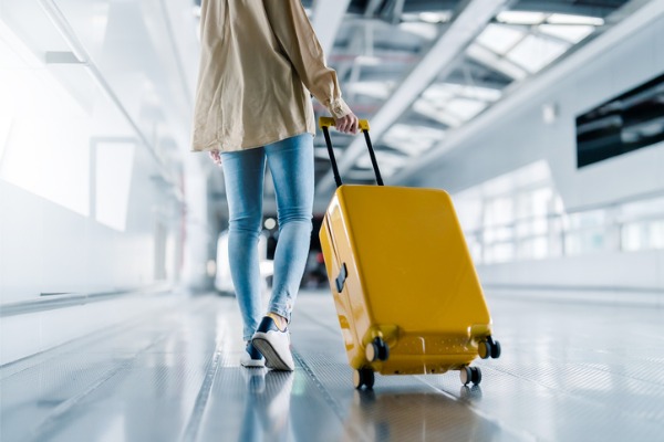 woman walking with rolling suitcase